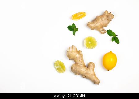 Ingwerwurzel, Zitronenscheiben und grüne frische Minze liegen isoliert auf weißem Hintergrund. Zusammensetzung des Konzepts „Food Balance and Detox“. Stockfoto