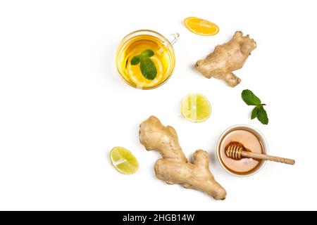 Tee, Ingwerwurzel, Honig, Zitronenscheiben und grüne frische Minze lagen isoliert auf weißem Hintergrund. Zusammensetzung des Konzepts „Food Balance and Detox“. Stockfoto