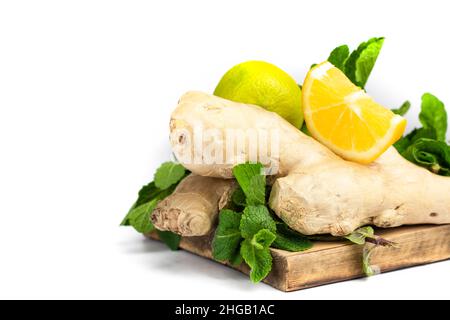 Ingwerwurzel, grüne frische Minze und Zitronen auf Holztablett Stockfoto
