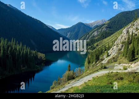 Alpensee Kolsay in einer Bergschlucht mit einer Bergstraße im Sommer, Draufsicht Stockfoto