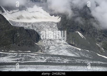 Nahaufnahme des Gletschers in felsigen Bergen mit Felsen und Wolken Stockfoto