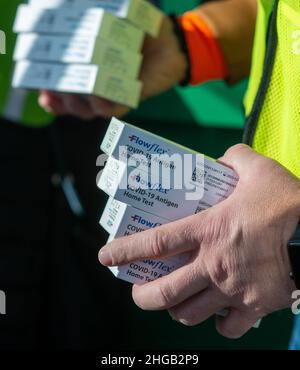 Langhorne, Usa. 19th Januar 2022. Ein Freiwilliger hält Tests, die gegeben werden, während Hunderte von Bucks County Bewohner warteten in einer schnellen Fahrt durch die Schlange auf dem Parkplatz, um kostenlose COVID-19 Rapid Test Kits Mittwoch, 19. Januar 2022 am Sesame Place in Langhorne, Pennsylvania zu erhalten. Es wurde erwartet, dass die Notfallverwaltungsbehörde und das Gesundheitsministerium des Bezirks in den nächsten Wochen von 10 bis 6 Uhr jeden Verteilungstag 300.000 Testkits ausliefern werden, solange der Vorrat reicht. Kredit: William Thomas Cain/Alamy Live Nachrichten Stockfoto