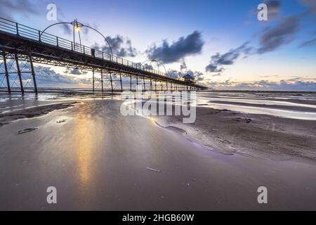 Southport Pier bei Sonnenuntergang nach einer Flut Stockfoto