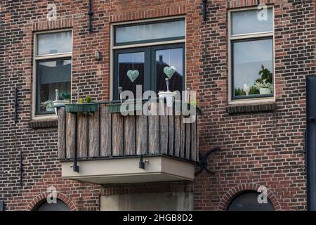 Schönes Backsteinhaus und seinen Balkon mit Herz in einem Fenster in Holland in der Altstadt. Stockfoto