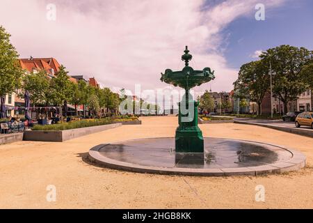 Brunnen auf dem Platz in der Stadt Vlisssingen in Holland. Der Hintergrund ist ein blauer Himmel mit weißen Wolken und die Morgensonne scheint. Stockfoto