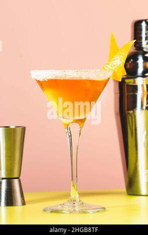 Alkoholischer Beiwagen-Cocktail mit Cognac, Likör, Zitronensaft und Eis. Pinkfarbener und grüner Hintergrund, Kopierbereich Stockfoto