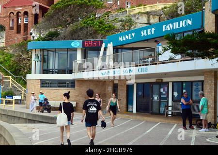 Menschen, die am Surf Lifesaving Pavilion in Manly in Sydney, Australien, vorbei laufen Stockfoto