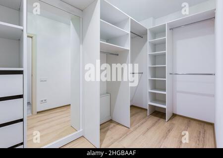 Das Innere einer leeren Ankleidekabine besteht aus vielen weißen Regalen Stockfoto