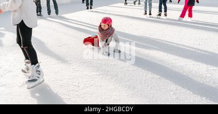 Slovakia.Bratislava.28.12.2018 .Soft,Selective Focus.Wintersport.People Eislaufen auf der City Park Ice Rink das Kind fiel auf die Eisbahn, während Stockfoto