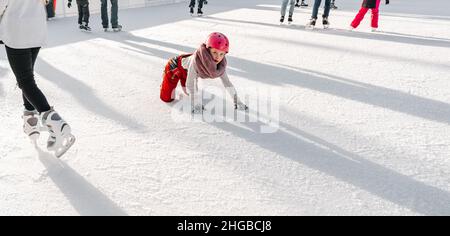 Slovakia.Bratislava.28.12.2018 .Soft,Selective Focus.Wintersport.People Eislaufen auf der City Park Ice Rink das Kind fiel auf die Eisbahn, während Stockfoto