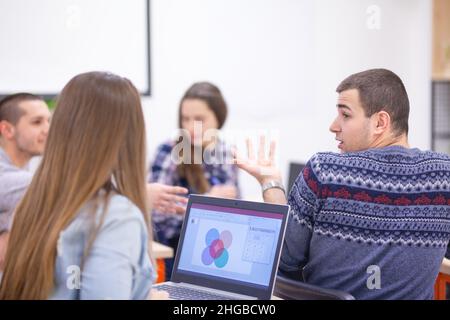 Die Schüler sprechen während des Unterrichts in einem modernen Klassenzimmer miteinander. Stockfoto