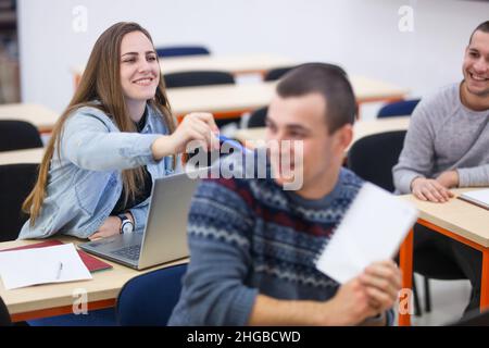 Die Schüler necken sich gegenseitig und haben Spaß während des Unterrichts in einem modernen Klassenzimmer Stockfoto