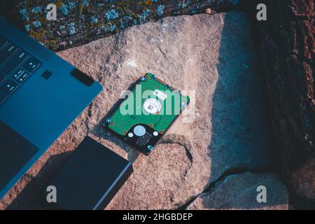 Laptop-ethernet-Kabel und Festplatte auf einem Felsen Stockfoto