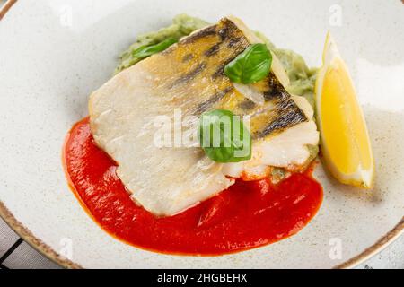 Gericht im Restaurant. Kabeljaufilet mit Sauce. Stockfoto