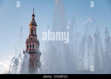 Wasser aus einem Brunnen, der vor einem der Türme der Plaza de España in Sevilla sprudelt (Panoramablick) Stockfoto