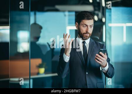 Wütender und nervöser Chef, der ins Telefon rief, während des Telefongesprächs mit dem Mitarbeiter, Geschäftsmann im modernen Büro mit Telefon Stockfoto