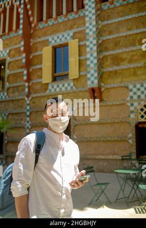 Spanien, Barcelona, 14/07/2021. Das Casa Vicens Haus in Barcelona, entworfen von Antoni Gaudí, heute ein Museum. Ein maskierter Mann hört sich einen Audioguide an. Stockfoto