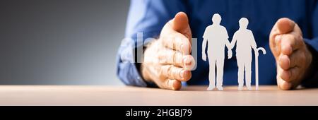 Handschutz Für Ältere Paare Ausschnittfiguren Über Dem Schreibtisch Stockfoto