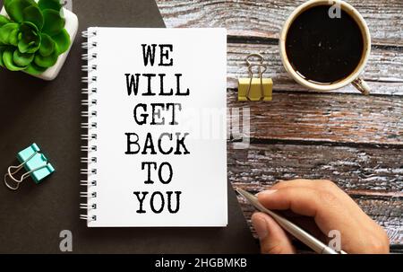 Closeup auf Geschäftsmann hielt eine Karte mit Text wir wird GET BACK TO YOU, Firmen-Konzept-Image mit soft-Fokus-Hintergrund und Vintage-Ton Stockfoto