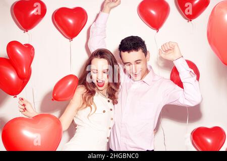 Mann mit seinem lieblichen Liebsten Mädchen tanzen und haben Spaß am Valentinstag von Lover. Valentinspaar. Pärchen sehr glücklich, Party, Lächeln, Lachen. Backgr Stockfoto