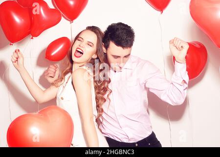 Mann mit seinem lieblichen Liebsten Mädchen tanzen und haben Spaß am Valentinstag von Lover. Valentinspaar. Pärchen sehr glücklich, Party, Lächeln, Lachen. Backgr Stockfoto