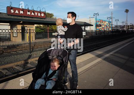 San Mateo, USA. 19th Januar 2022. Die am 11. April 2021 aufgenommene Datei zeigt einen Mann mit einer Gesichtsmaske aus dem Jahr KN95 und Kindern an einem Bahnhof in San Mateo, Kalifornien, USA. US-Präsident Joe Bidens Regierung wird diese Woche damit beginnen, 400 Millionen kostenlose nicht-chirurgische N95 Gesichtsmasken an landesweite Vertriebsstellen zu verschiffen, als Teil der Bemühungen, die aufsteigende Omicron COVID-19-Variante zu bekämpfen, USA Today, am 19. Januar 2022 zitierte eine offizielle Quelle wie es heißt. Quelle: Wu Xiaoling/Xinhua/Alamy Live News Stockfoto