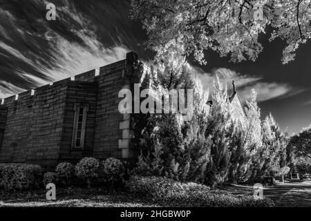 Infrarotfotografie der Friedhofslandschaft mit Krypta und Bäumen. Mit einer Nikon IR-konvertierten Kamera. Stockfoto