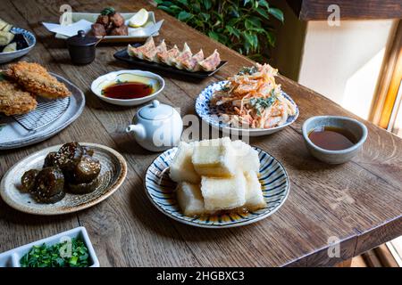 Eine Vielzahl japanischer Gerichte auf einem rustikalen Holztisch. Stockfoto