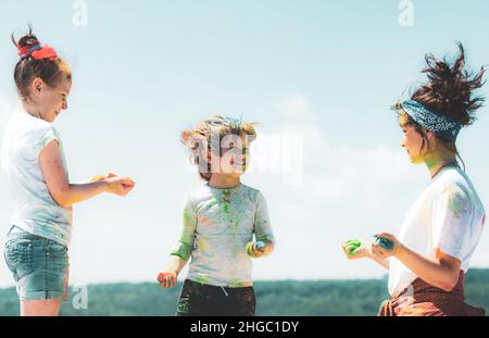 Kinder spielen Farben. Holi Festival der Farben. Kinder mit Gesicht mit Farben verschmiert. Kinder Mädchen und Jungen feiern Indian holi Festival mit bunten Stockfoto