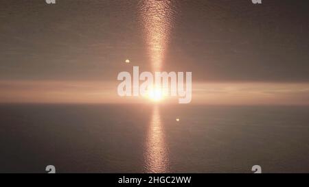 Schöner Sonnenuntergang im Meer mit einem Spiegelhorizont-Effekt. Abendsonne am Horizont mit Lichtes, Aufbruchthema Stockfoto
