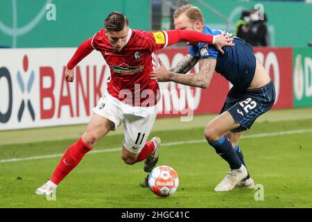 Hoffenheim, Deutschland. 19th Januar 2022. Ermedin Demirovic (L) aus Freiburg siegt mit Kevin Vogt aus Hoffenheim beim Deutschen Cup-Lauf 16 zwischen der TSG Hoffenheim und dem SC Freiburg am 19. Januar 2022 in Hoffenheim. Quelle: Ulrich Hufnagel/Xinhua/Alamy Live News Stockfoto