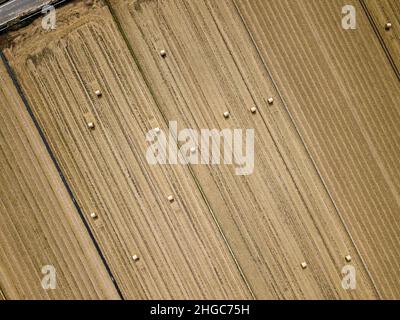 Luftaufnahme eines geernteten Ackerlandes mit Strohballen. Stockfoto