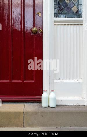 Milchflaschen vor der Haustür entlang der College Street. Ludlow, Shropshire, England Stockfoto