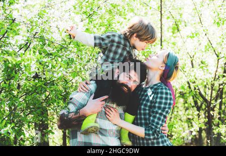 Glückliche Familienbauern, die mit Spud auf dem Frühlingsfeld arbeiten. Erdkonzept. Gartenarbeit im Frühjahr - glückliche Familie ernten und viel Spaß haben. Stockfoto