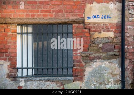 Ye alten Gefängnis Graffiti neben einem versperrten Fenster in der Seite einer alten Backsteinmauer. Castle Square, Ludlow, Shropshire, England Stockfoto