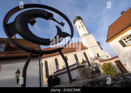 Grafing, Deutschland. 13th Januar 2022. Die katholische Kirche St. Ägidius und das Pfarrhaus (r) im Dorfzentrum bei München. Eine vom Bistum München beauftragte Kanzlei will dort am 20. Januar 2022 ein Gutachten zu Missbrauchsfällen vorlegen. Es wird sich auch um den Fall eines Priesters handeln, der der Pfarrei in der Pfarrei in der Region von Archling an der Alz zugeteilt wurde, obwohl er zuvor wegen Kindesmissbrauchs verurteilt worden war. Nach Angaben der Diözese gibt es Hinweise darauf, dass er auch in der Diözese in der Auflehnung war. Kredit: Peter Kneffel/dpa/Alamy Live Nachrichten Stockfoto