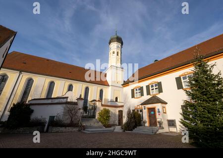 Grafing, Deutschland. 13th Januar 2022. Die katholische Kirche St. Ägidius und das Pfarrhaus (r) im Dorfzentrum bei München. Eine vom Bistum München beauftragte Kanzlei will dort am 20. Januar 2022 ein Gutachten zu Missbrauchsfällen vorlegen. Es wird sich auch um den Fall eines Priesters handeln, der der Pfarrei in der Pfarrei in der Region von Archling an der Alz zugeteilt wurde, obwohl er zuvor wegen Kindesmissbrauchs verurteilt worden war. Nach Angaben der Diözese gibt es Hinweise darauf, dass er auch in der Diözese in der Auflehnung war. Kredit: Peter Kneffel/dpa/Alamy Live Nachrichten Stockfoto