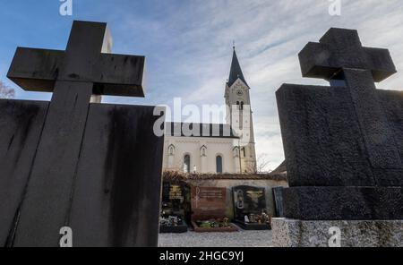 In Der Stadt, Deutschland. 13th Januar 2022. Die Grabsteinkreuze ragen in den Himmel vor der katholischen Kirche St. Nikolaus. Eine vom Bistum München beauftragte Kanzlei will dort am 20. Januar 2022 ein Gutachten zu Missbrauchsfällen vorlegen. Hier wird es auch um den Fall eines Priesters gehen, der in der Pfarrei in der Pfarrei in der Gemeinde von Archling an der Alz ernannt wurde, obwohl er zuvor wegen Kindesmissbrauchs verurteilt worden war. Nach Angaben der Diözese gibt es Hinweise darauf, dass er auch in der Diözese in der Auflehnung war. Kredit: Peter Kneffel/dpa/Alamy Live Nachrichten Stockfoto