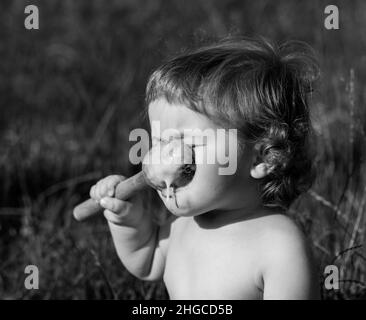 Lachend essen Baby Mädchen mit schmutzigem Gesicht. Stockfoto