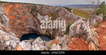 Prachtvoller und majestätischer roter See in der Nähe von Imotski, einem Krater oder Sinkhole aus Kalkstein, der mit mehr als 500m Tiefen gefüllt ist. Luftdrohnenfoto. Stockfoto