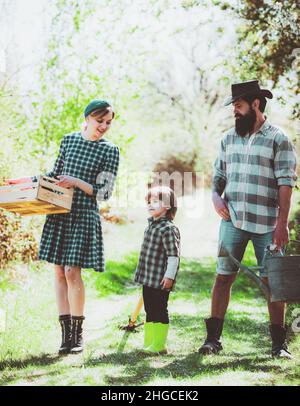 Familie auf dem Bauernhof auf dem Land Hintergrund. Familie, die gemeinsam durch das frühlingsgeerntete Feld geht. Landwirtschaft der Arbeiterfamilie. Öko-Farm. Familie Stockfoto