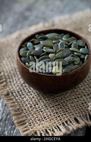 Kürbiskerne in einer Schüssel über Holz- Oberfläche Stockfoto