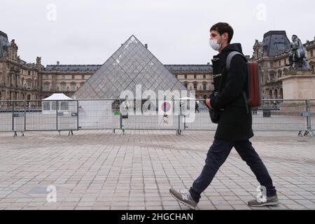 Paris, Frankreich. 19th Januar 2022. Ein Mann geht an der Pyramide des Louvre-Museums in Paris, Frankreich, vorbei, 19. Januar 2022. Die COVID-19-Situation in Frankreich verschlechtert sich weiter, da in den letzten 24 Stunden 464.769 neue Fälle entdeckt wurden, wie die Gesundheitsbehörde des Landes am Dienstag mitteilte. Kredit: Gao Jing/Xinhua/Alamy Live Nachrichten Stockfoto