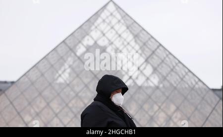 Paris, Frankreich. 19th Januar 2022. Eine Frau geht an der Pyramide des Louvre-Museums in Paris, Frankreich, vorbei, 19. Januar 2022. Die COVID-19-Situation in Frankreich verschlechtert sich weiter, da in den letzten 24 Stunden 464.769 neue Fälle entdeckt wurden, wie die Gesundheitsbehörde des Landes am Dienstag mitteilte. Kredit: Gao Jing/Xinhua/Alamy Live Nachrichten Stockfoto