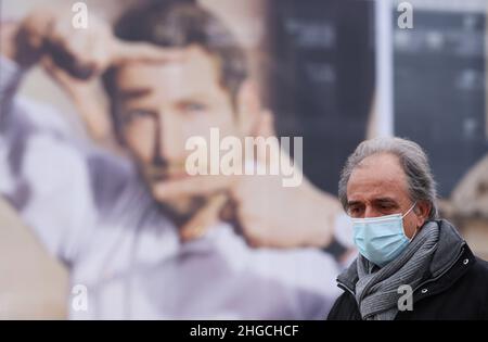 Paris, Frankreich. 19th Januar 2022. Ein Mann kommt an einem Plakat in Paris, Frankreich, vorbei, 19. Januar 2022. Die COVID-19-Situation in Frankreich verschlechtert sich weiter, da in den letzten 24 Stunden 464.769 neue Fälle entdeckt wurden, wie die Gesundheitsbehörde des Landes am Dienstag mitteilte. Kredit: Gao Jing/Xinhua/Alamy Live Nachrichten Stockfoto