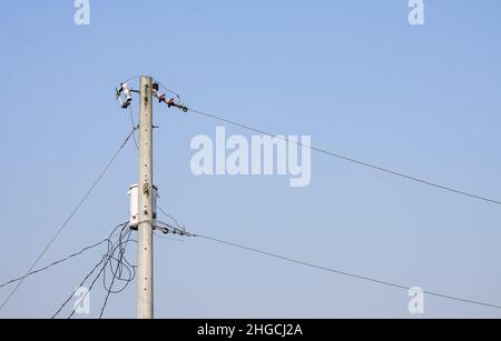 Hochspannungs-Stromübertragungsmast Nahaufnahme mit Kopierraum unter dem blauen Himmel Stockfoto