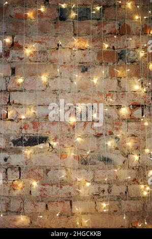 Rote Backsteinmauer mit flacher Sicht auf weihnachtslichter Stockfoto