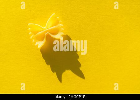 Nahaufnahme der Farfalle. Paste auf einem gelben Hintergrund in hellem Licht Stockfoto
