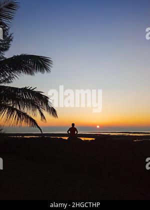 Toller Sonnenuntergang Am Strand Und Allein Sitzender Mann Auf Dem Stein Stockfoto