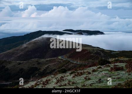 Schöner Panoramablick auf die mit Wolken gefüllte Berglandschaft, von einem Hügel in der Nähe von Rabaçal, Madeira aus gesehen Stockfoto